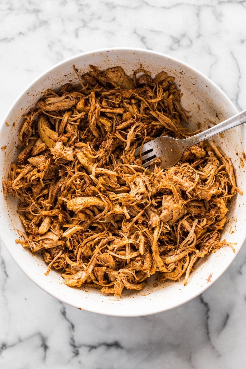 Seasoned shredded chicken in a bowl for chicken taquitos