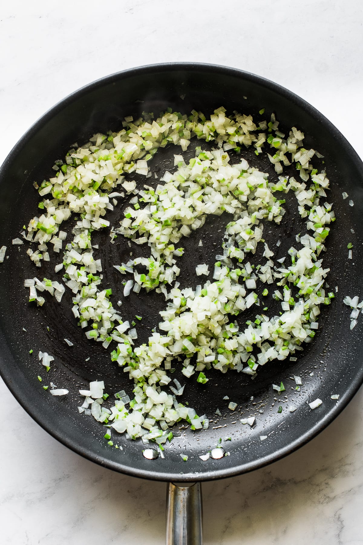 Sauteed onions and peppers in a skillet.